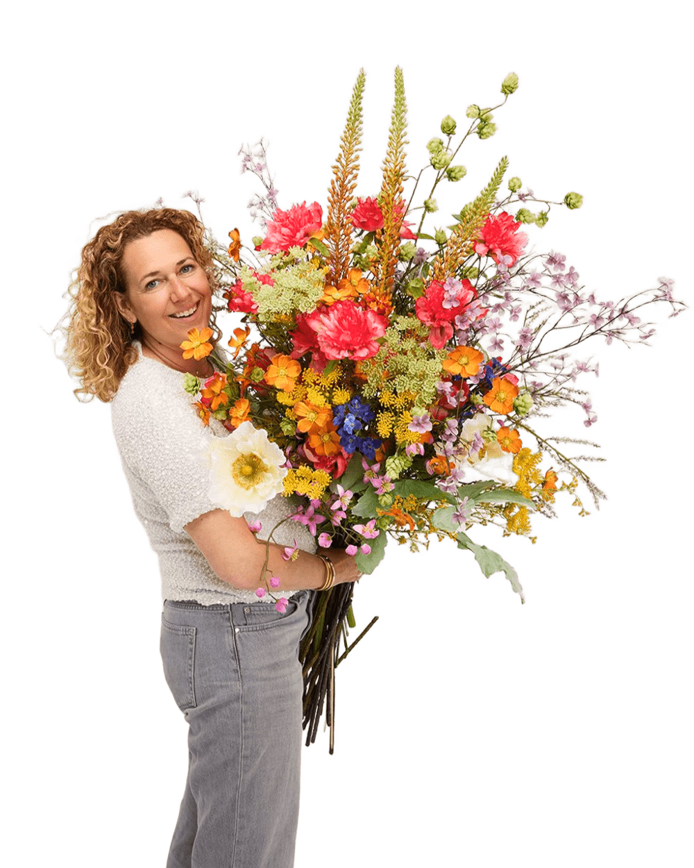 Een lachende vrouw met krullend haar houdt een weelderig, kleurrijk zijden boeket vast.